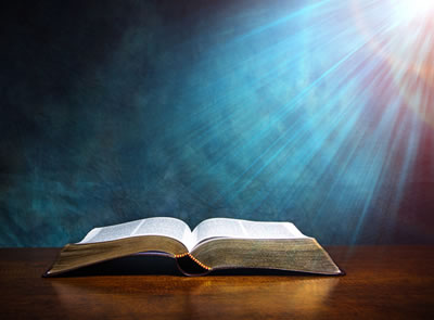 Open bible with bright light shining on it.