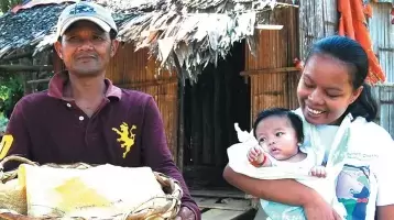 A Subanen crafter carries her baby in a sling.