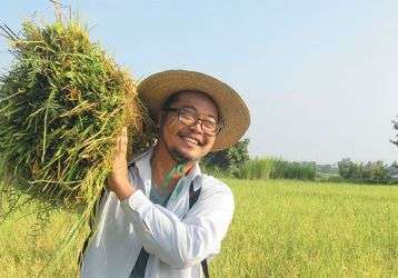 Fr. Kurt holding harvested rice.