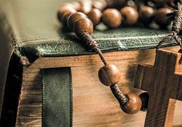 Rosary draped over a bible