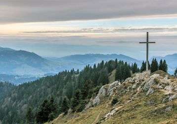 A cross on top of a rocky mountain
